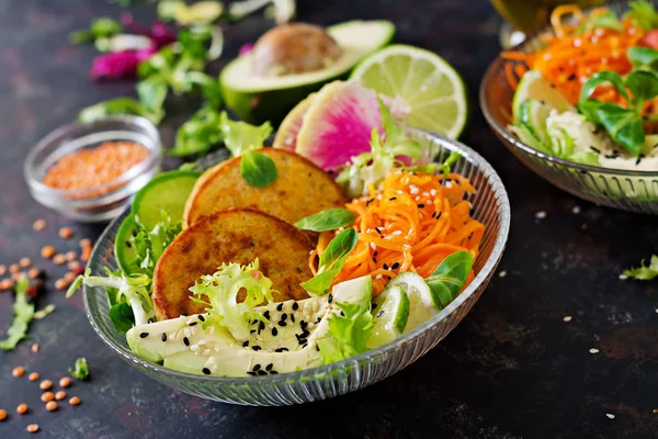 Vegan buddha bowl dinner food table. Healthy food. Healthy vegan lunch bowl. Fritter with lentils and radish, avocado, carrot salad.