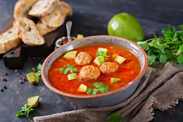 Spicy tomato soup with meatballs and vegetables. Served with avocado and parsley. Healthy dinner — Stock Image Spicy Tomato Soup Meatballs Vegetables Served Avocado Parsley Healthy Dinner Royalty Free Stock Images