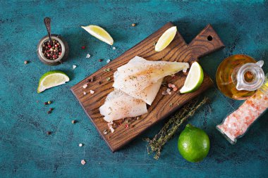 Yemek pişirmek için hazırlanan bir ahşap tahta üzerinde beyaz balık fileto. Düz yatıyordu. Üstten Görünüm