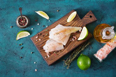 Yemek pişirmek için hazırlanan bir ahşap tahta üzerinde beyaz balık fileto. Düz yatıyordu. Üstten Görünüm