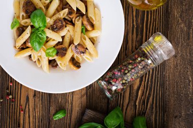 Vejetaryen sebze makarna penne ahşap masa üzerinde beyaz kase mantar ile yakın çekim fotoğraf. Vegan gıda.
