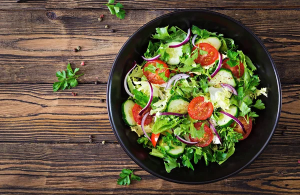 トマト キュウリ 赤玉ねぎ レタスのベジタリアン サラダの平面図を残します 健康的な夏のビタミンのメニュー ビーガン野菜食糧 夕食のテーブル フラットを置く — ストック写真