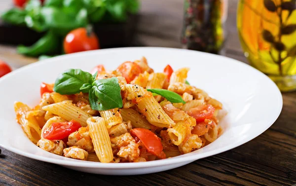 Penne Pasta Томатном Соусе Курицей Помидорами Украшенная Лимоном Деревянном Столе — стоковое фото