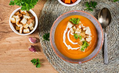 Maydanoz ve kızarmış ekmekle servis edilen kabak çorbası. Vejetaryen çorbası. Şükran Günü yemeği. Cadılar Bayramı yemeği. Üst görünüm