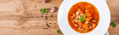 Kabaklı domates çorbası ve beyaz kasede beyaz fasulye. Pankart. Üst görünüm