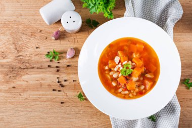Kabaklı domates çorbası ve beyaz kasede beyaz fasulye. Üst görünüm