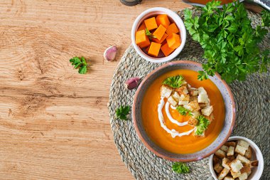 Maydanoz ve kızarmış ekmekle servis edilen kabak çorbası. Vejetaryen çorbası. Şükran Günü yemeği. Cadılar Bayramı yemeği. Üst görünüm