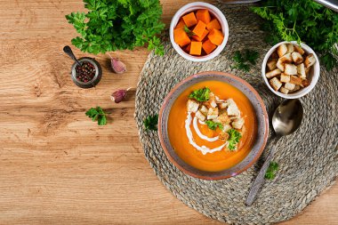 Maydanoz ve kızarmış ekmekle servis edilen kabak çorbası. Vejetaryen çorbası. Şükran Günü yemeği. Cadılar Bayramı yemeği. Üst görünüm