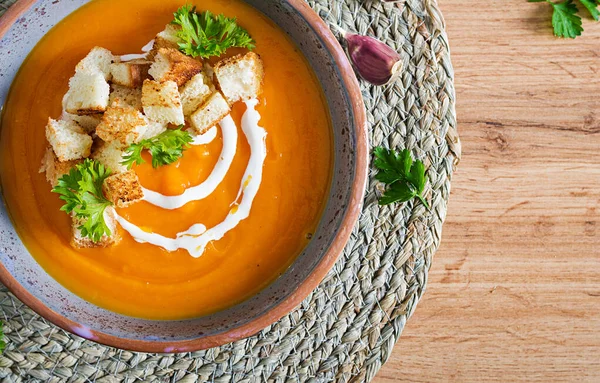 Sopa de calabaza en un tazón servido con perejil y croutons. Vegano s —  Fotos de Stock