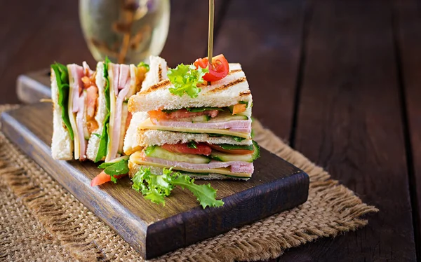 Club Sandwich Ζαμπόν Ντομάτα Αγγούρι Τυρί Και Ρόκα Ξύλινο Φόντο — Φωτογραφία Αρχείου