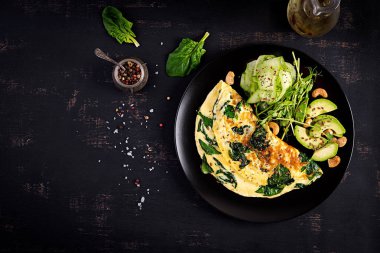 Ketogenik, paleo diyet kahvaltısı. Ispanaklı omlet, avokado, salatalık. Üst görünüm, alanı kopyala