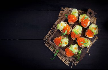 Somon kırmızısı havyarlı kanepe. Öğle yemeği için sandviç. Lezzetli yemek. Üst görünüm, genel görünüm