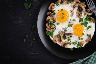 Kızarmış yumurta, mantar ve ıspanak. Keto, paleo kahvaltısı. Üst görünüm, alanı kopyala