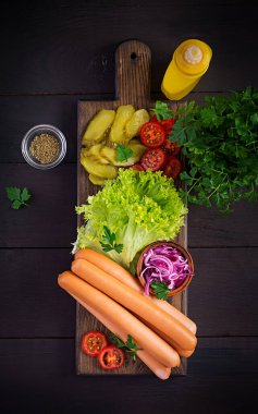 Sosisli, salatalık turşusu, domates, kırmızı soğan ve ahşap kaplamalı marul. Yaz sosislisi. Üst görünüm