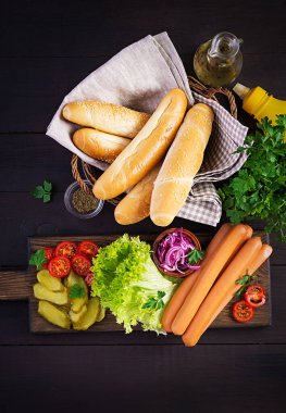 Sosisli, salatalık turşusu, domates, kırmızı soğan ve ahşap kaplamalı marul. Yaz sosislisi. Üst görünüm