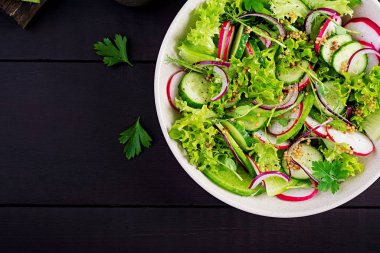 Sağlıklı vejetaryen yemeği. Vejetaryen sebze salatası, turp, salatalık, marul ve kırmızı soğan. Üst görünüm, alanı kopyala