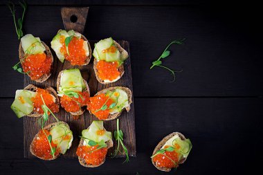 Somon kırmızısı havyarlı kanepe. Öğle yemeği için sandviç. Lezzetli yemek. Üst görünüm, genel görünüm