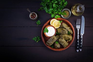 Dolma. Stuffed grape leaves with rice and meat on dark table. Middle eastern cuisine. Top view, overhead, copy space clipart