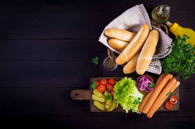 Sosisli, salatalık turşusu, domates, kırmızı soğan ve ahşap kaplamalı marul. Yaz sosislisi. Üst görünüm