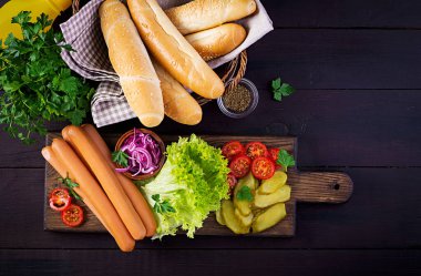 Sosisli, salatalık turşusu, domates, kırmızı soğan ve ahşap kaplamalı marul. Yaz sosislisi. Üst görünüm