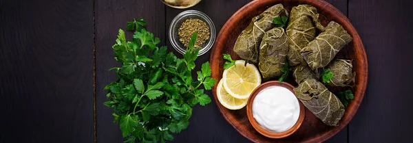 Dolma. Gevulde druivenbladeren met rijst en vlees op donkere tafel. Mi — Stockfoto