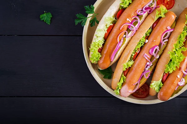 Hot Dog Kolbásszal Pácolt Uborkával Paradicsommal Vöröshagymával Salátával Sötét Háttéren — Stock Fotó