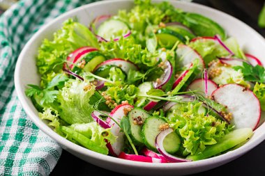 Sağlıklı vejetaryen yemeği. Vejetaryen sebze salatası turp, salatalık, marul ve kırmızı soğan..