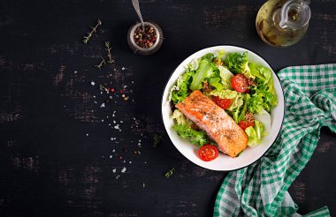 Fırında somon filetosu ve taze sebze salatası. Üst görünüm, genel görünüm