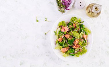 Fırında balık somonu, brokoli, marul, kırmızı soğan ve sos salatası. Balık menüsü. Deniz mahsulleri, somon. Üst görünüm, genel görünüm