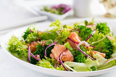 Fırında balık somonu, brokoli, marul, kırmızı soğan ve sos salatası. Balık menüsü. Deniz ürünleri - somon..