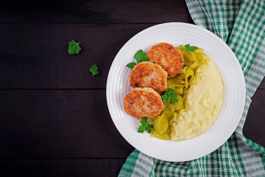 Ev yapımı pirzola, patates püresi ve beyaz tabakta salatalık turşusu ile köfte. Üst görünüm, genel görünüm, kopyalama alanı.