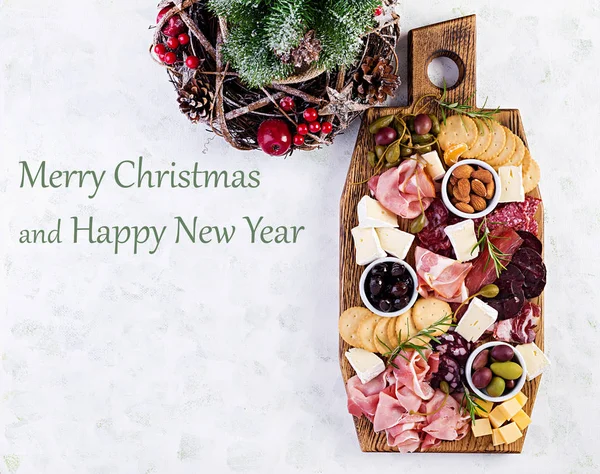 プロシュット サラミ チーズ クラッカー オリーブとアンティパストプレート クリスマステーブルトップビュー オーバーヘッド — ストック写真