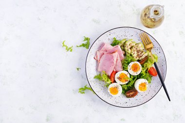 Ketogenik / paleo diyeti. Haşlanmış yumurta, jambon, avokado ve taze salata. Keto kahvaltısı. Brunch olsun. Üst görünüm, genel görünüm