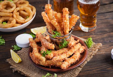 Peynir çubukları ve soğan halkaları soslu hamurda. Bira aperatifleri. Boşluğu kopyala