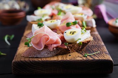 Prosciutto / jamon geleneksel İtalyan Antipasto 'lu Ekmek, peynir ve bıldırcın yumurtası ile nefis atıştırmalıklar. Sağlıklı yiyecekler, tapas