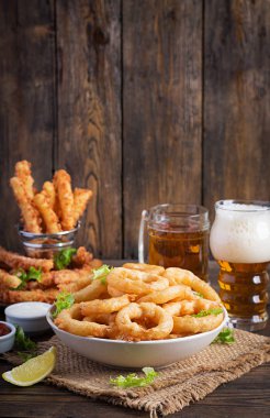 Soslu ve peynirli hamurlu soğan halkaları. Bira aperatifleri. Boşluğu kopyala
