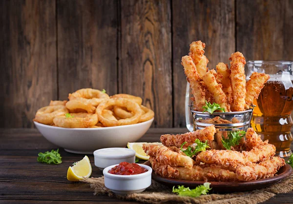 Peynir çubukları ve soğan halkaları soslu hamurda. Bira aperatifleri. Boşluğu kopyala