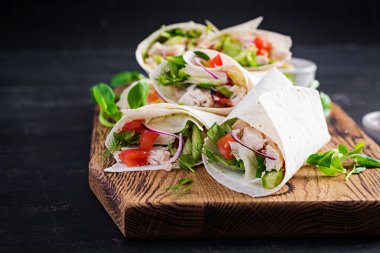 Tavuklu taze tortilla ve tahta tahtada taze sebzeler. Tavuk dürüm. Meksika yemeği. Sağlıklı gıda konsepti. Meksika mutfağı.