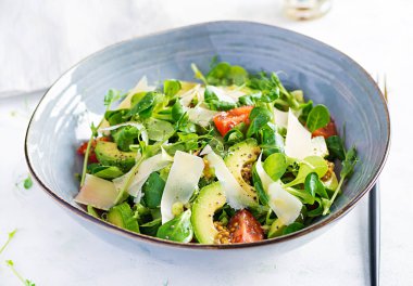 Taze sebzelerden oluşan sağlıklı bir salata. Domates, avokado, mısır salatası, bezelye filizi ve kase içinde chia tohumu. Paleo diyet menüsü.