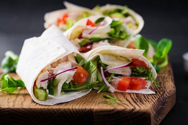 Tavuklu taze tortilla ve tahta tahtada taze sebzeler. Tavuk dürüm. Meksika yemeği. Sağlıklı gıda konsepti. Meksika mutfağı.