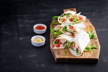 Tavuklu taze tortilla ve tahta tahtada taze sebzeler. Tavuk dürüm. Meksika yemeği. Sağlıklı gıda konsepti. Meksika mutfağı.