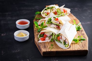 Tavuklu taze tortilla ve tahta tahtada taze sebzeler. Tavuk dürüm. Meksika yemeği. Sağlıklı gıda konsepti. Meksika mutfağı.