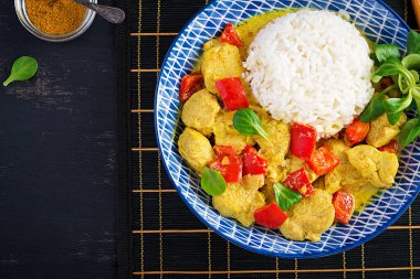 Hint usulü körili tavuk, basmati pilavı ve mavi kase. Geleneksel Hint yemeği. Tavuk tikka masala. Hint mutfağı. Üst manzara, düz uzanma