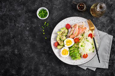 Ketogenik diyet, kahvaltı. Yumurta, balık ve avokado, marul ve tohum. Düşük karbonhidratlı yüksek yağlı kahvaltı. Keto / Paleo menüsü. Üst manzara, düz uzanma