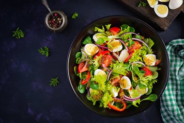 Sebzeli taze salata, domates, kırmızı soğan, marul ve bıldırcın yumurtası. Sağlıklı gıda ve diyet konsepti. Vejetaryen yemeği. Üst görünüm, genel görünüm
