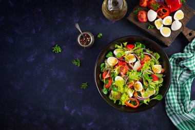 Sebzeli taze salata, domates, kırmızı soğan, marul ve bıldırcın yumurtası. Sağlıklı gıda ve diyet konsepti. Vejetaryen yemeği. Üst görünüm, genel görünüm