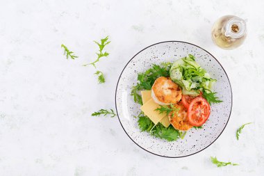 Ketogenik öğle yemeği. Domatesli tavuk burger, salatalık, peynir ve ekmeksiz roka salatası. Tavuk köftesi. Sağlıklı yiyecekler. Keto / paleo diyeti. Üst görünüm, genel görünüm