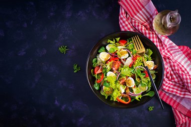Sebzeli taze salata, domates, kırmızı soğan, marul ve bıldırcın yumurtası. Sağlıklı gıda ve diyet konsepti. Vejetaryen yemeği. Üst görünüm, genel görünüm