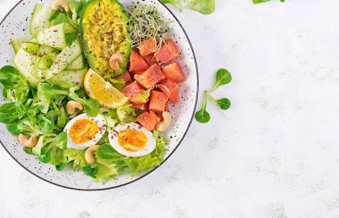 Ketogenik diyet kahvaltısı. Sebzeli tuzlu somon salatası, salatalık, yumurta ve avokado. Keto / Paleo öğle yemeği. Üst görünüm, genel görünüm