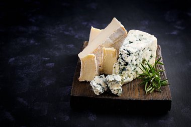 Tahta tahtalarda peynir. Ahşap arka planda Camembert ve Dorblu. Süt ürünleri